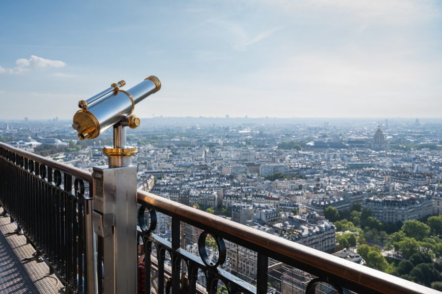 Panoramic view from second floor of Eiffel tower in Paris. View of the buildings, parks. Paid telescope for close up views, selective focus